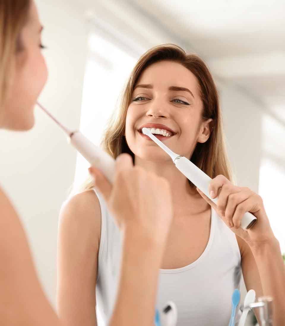 a man checking his CEREC dental crowns with a mirror