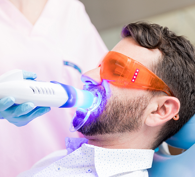 Bearded man having professional teeth whitening performed