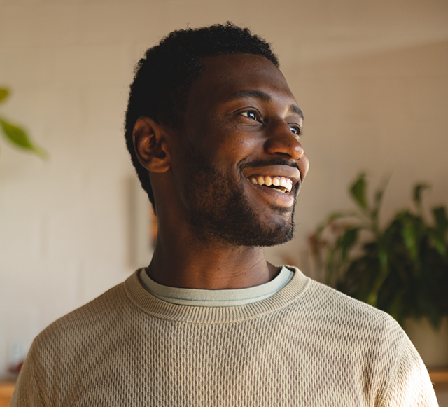 Man in light brown shirt smiling