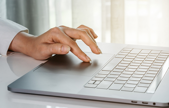 Hand reaching to type on laptop